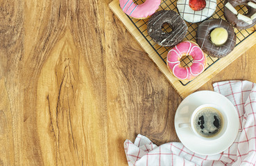 Donuts and coffee on wooden table, top view
