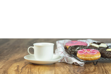 Coffee and donuts on wooden table with white background.