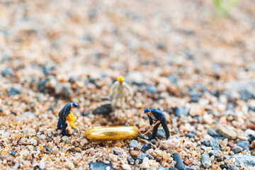 Miniature people : worker team digging  gold rings on the floor , Business Growth concept