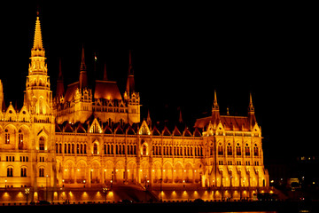 Budapest Hungary, 05.29.2019 Hungarian Parliament Building on the banks of the Danube River. night Budapest, glowing in gold. facade and roof of an old building