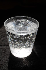 glass of water with ice on black background