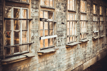Wooden wall close-up and old wooden windows on the facade of an old house