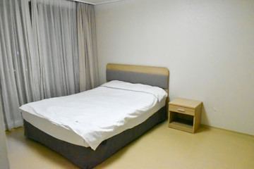 The bedroom consists of a bed, a shelf, a window, a curtain.