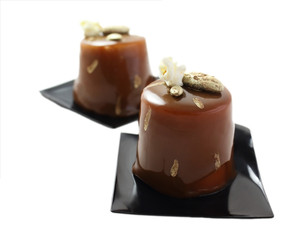 Chocolate and coffee desserts with mirror glaze, cocoa nibs and popcorn on black coasters