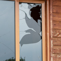 Close up view of cracked and broken glass window. Vandalism fracture