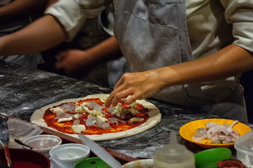 Obraz na płótnie Canvas ピザ作り。 イタリンピッツァを調理するシェフ。マスタークラスで 学ぶ。 自家製ピザを準備する。