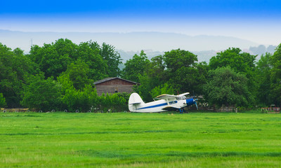 old small airplane on the farm field.