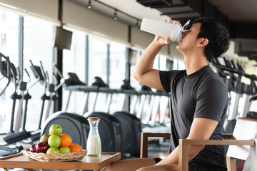 Handsome man drinking protein shake milk and many kind of fruits for nourishing body daily. People...