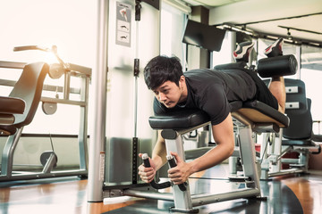 Asian sport man stretching and lifting weight by two legs when facing down for stretching muscle at...