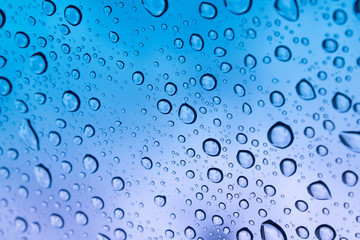 colored raindrops on glass close up