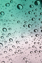 colored raindrops on glass close up