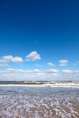 Seascape with layer of clouds and blue cloudless sky