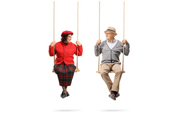 Elderly couple on swings looking at each other