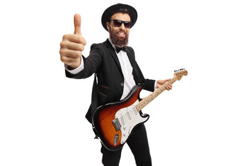 Cheerful male guitarist with an electric guitar showing thumbs up