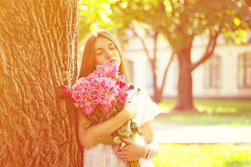 beautiful girl, no makeup, natural beauty, feminism. woman in a white dress, crosswise with a bouquet of peonies