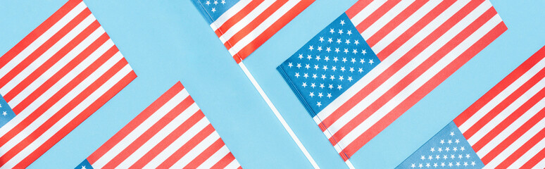 panoramic shot of national usa flags on blue background