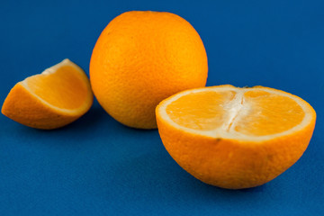 Ripe juicy delicious orange on blue background. Healthy eating and dieting concept