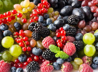 Ripe blueberries, red currants, backberries, grapes, plums and raspberries. Top view.