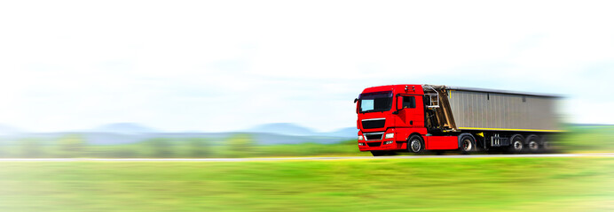 Transportation industry banner. Modern red generic truck with load moving fast on the highway - motion blur effect (copy space)