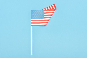 top view of american flag on stick on blue background