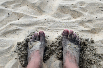  Female feet. Bare feet in the sand. The coast of the sea.