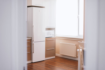 Fototapeta na wymiar Modern style white clean kitchen interior, minimalist concept, sunny