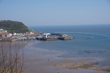 Fototapeta na wymiar View from clifftops down to harbour in Scarborough, UK on a clear blue sky sunny day