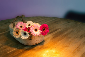 beautiful bouquet of bright flowers in basket on wooden table