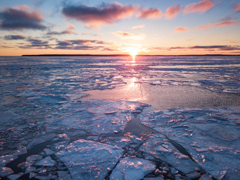 Warm rays of setting sun illumine icy Ontario lake