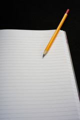 image of a notebooks and pencil on black background, close-up, selective focus