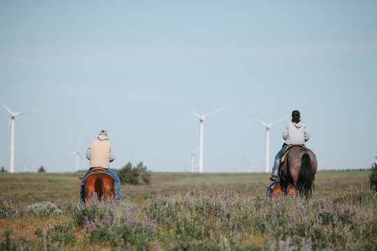 father and daughter on horseback ride across pasture