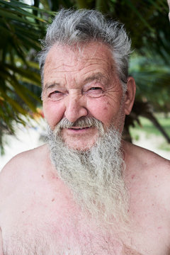 Portrait of senior bearded man at tropical beach. Holidays.