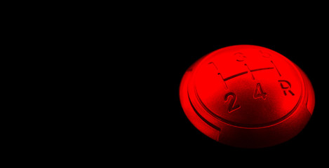 Close up view of a red gear lever shift isolated on black background. Manual gearbox. Car interior...