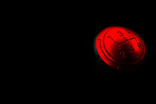 Close up view of a red gear lever shift isolated on black background. Manual gearbox. Car interior details. Car transmission. Soft lighting. Abstract view. Car detailing