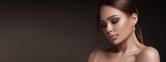 Beauty portrait of model with natural make-up. Fashion shiny highlighter on skin, sexy gloss lips make-up