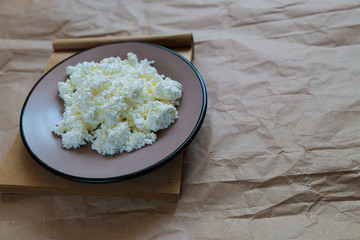 cottage cheese in a saucer on the old paper background