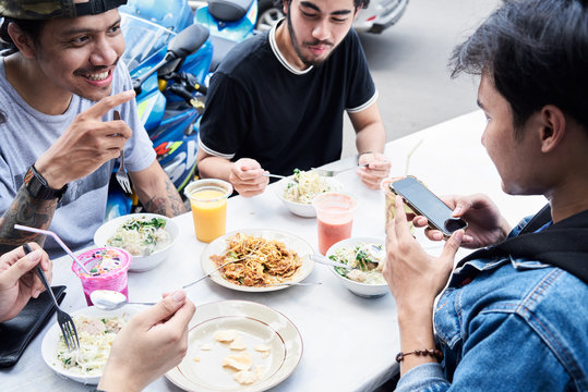Using technology on the table while eating lunch together with friends.