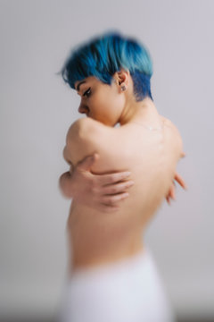 blue haired model posing in studio, photo taken with a lens blur effect