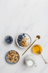 Copy space porridge with oat, milk, blueberries and honey on white background