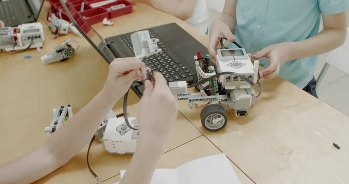 Curious kids working on a functional programable robot during robotics class at school. 4K UHD 60 FPS SLOW MOTION