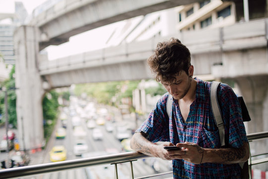Young alternative man using a mobile phone in the city
