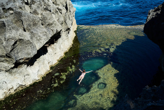 Traveler swimming relaxed at natural pool in summer. Freedom