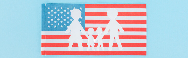 panoramic shot of paper cut white family on national american flag on blue background