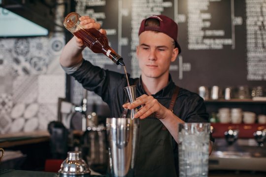Barman creating cocktail at bar counter