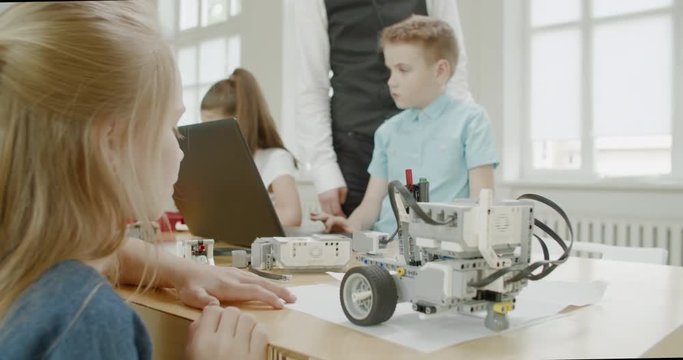 Curious kids working on a functional programable robot during robotics class at school. 4K UHD 60 FPS SLOW MOTION