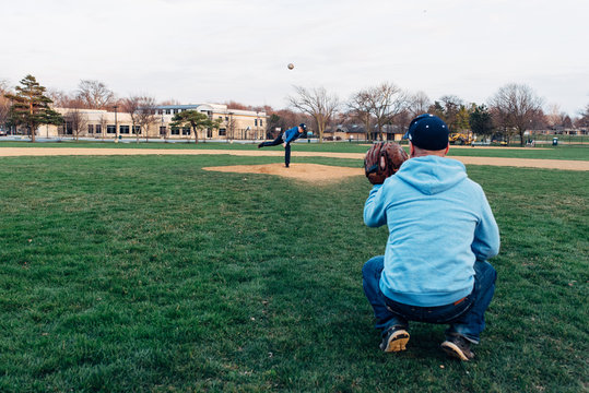 Father and son playing catch on a field