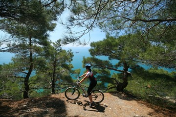 Fototapeta na wymiar Cyclist in cedar forest on the Black sea coast, Russia.