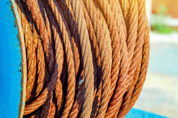 Rusty metal rope wound on a reel. Vintage metal background