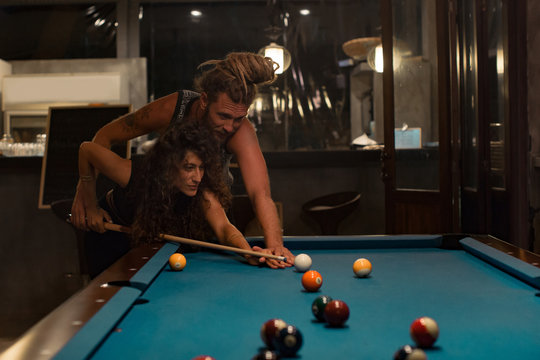 Couple playing pool in a bar