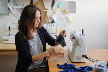 Female tailor working in in the sewing workshop.